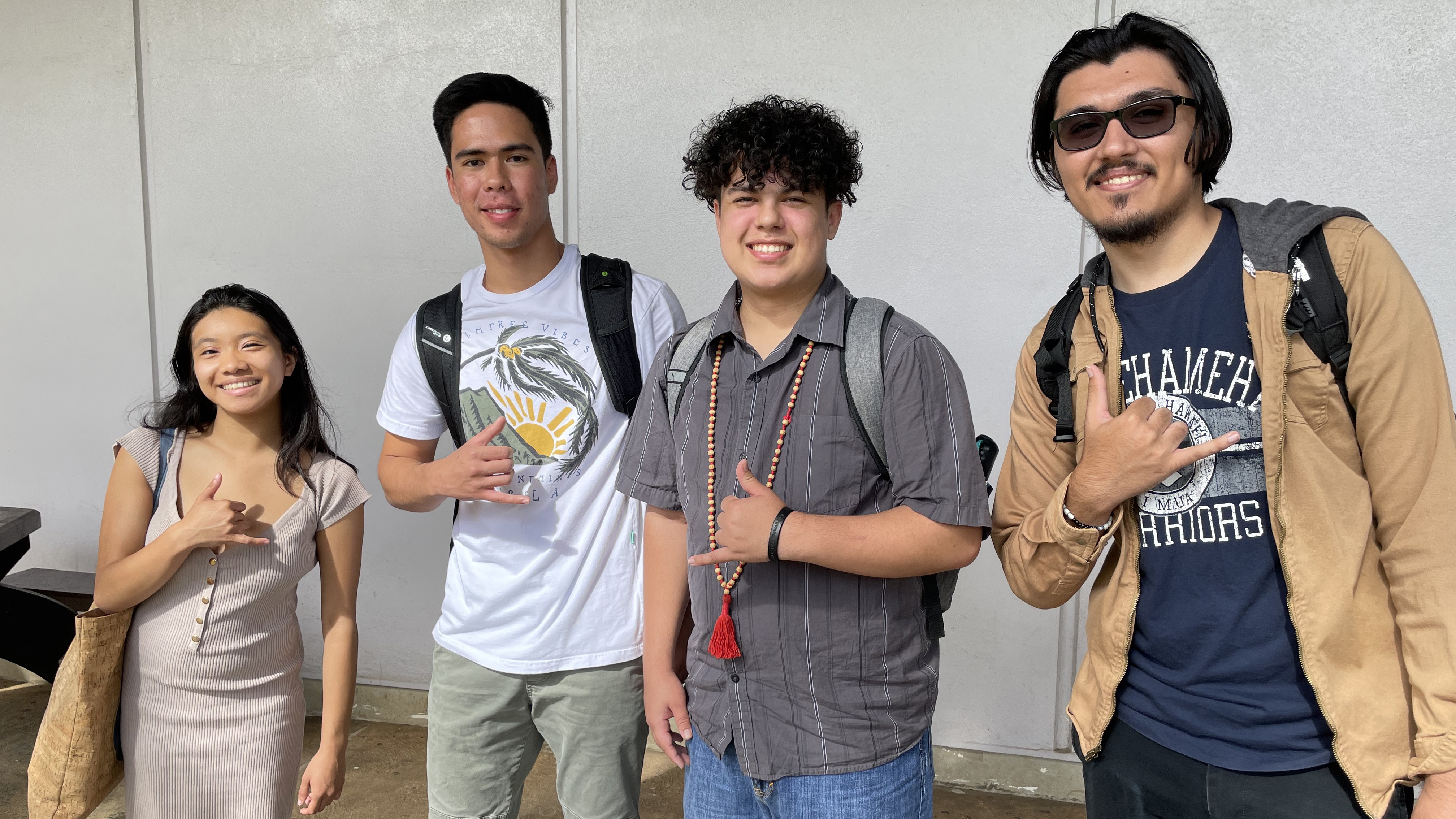 students smiling and giving the shaka